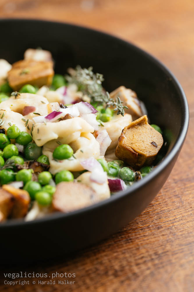 Stock photo of Tortellini with peas and Vegan Sausages