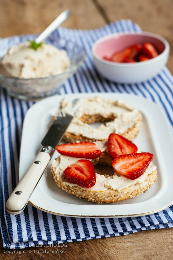 Stock photo of Bagel with fresh strawberries on homemade vegan cream cheese