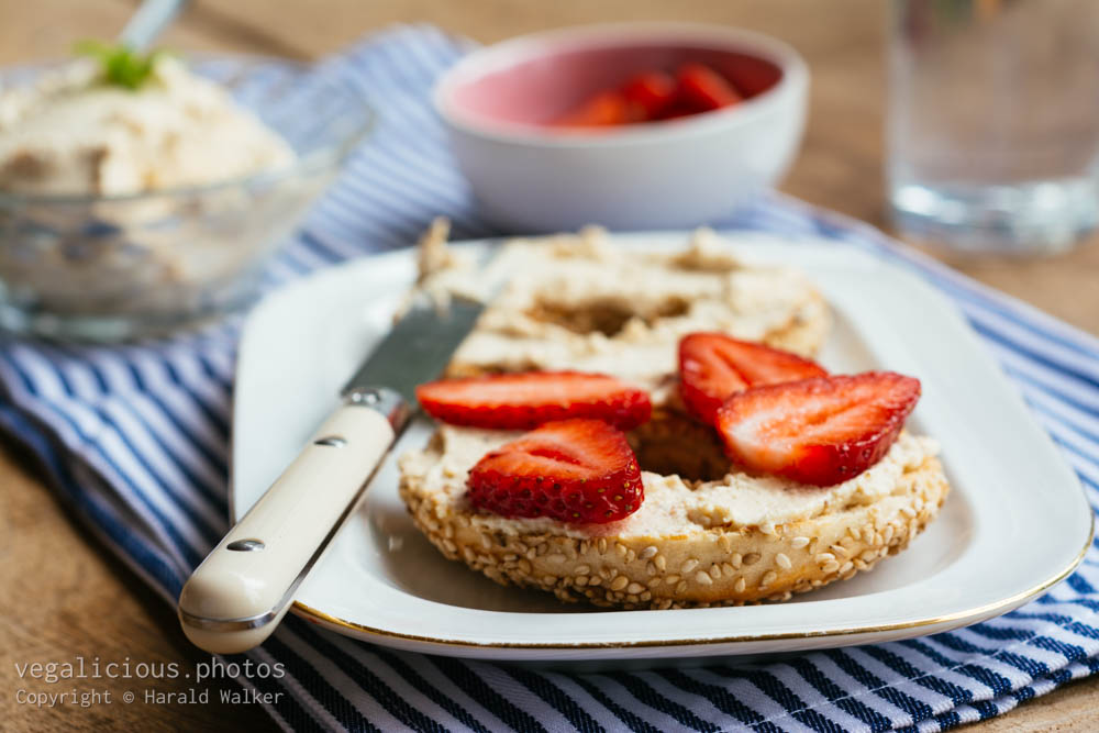 Stock photo of Bagel with fresh strawberries on homemade vegan cream cheese