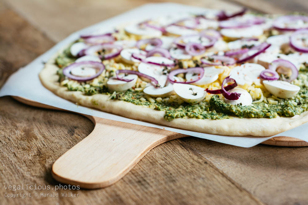 Stock photo of Making rucola and basil pesto pizza